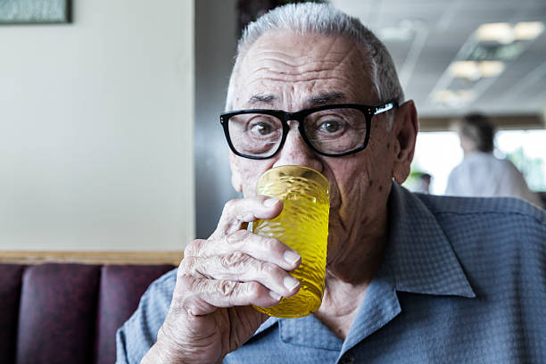 istock Elderly Senior Man Diner Drinking Water in Restaurant 616881516