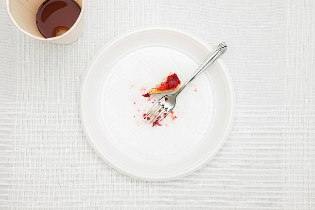 Leftover in plastic plate on white tablecloth stock photo