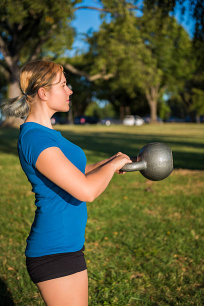 istock Young fit woman swinging heavy kettlebell 616881600