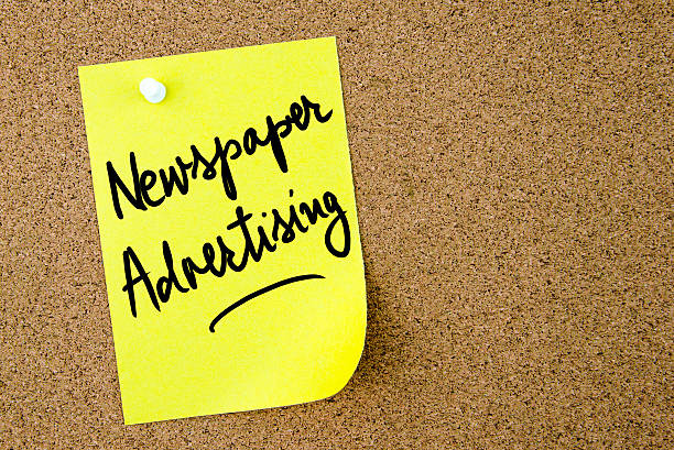 istock Newspaper Advertising text written on yellow paper note 616882410
