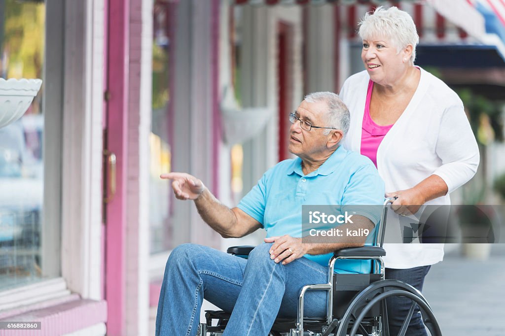 Senior Couple Man In Wheelchair Window Shopping Stock Photo - Download  Image Now - Community Outreach, Disability, Pushing - iStock