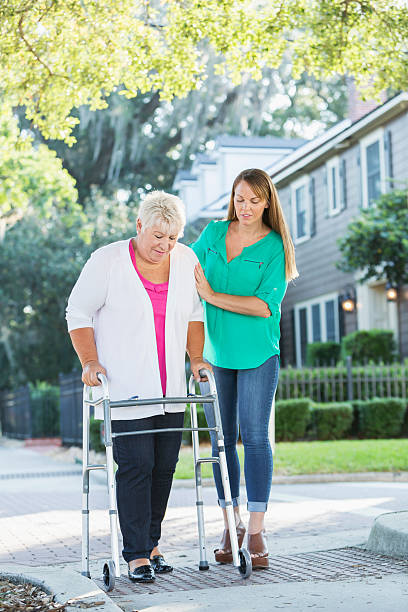istock Women helping her mother use walker 616882914