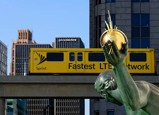Downtown Detroit Michigan Street Scene Detroit, USA - October 23, 2016: Downtown Detroit Michigan with Spirit of Detroit sculpture created by artist Marshall Fredericks. In the background, a People Mover car advertising for Sprint passes by. sprint nextel stock pictures, royalty-free photos & images