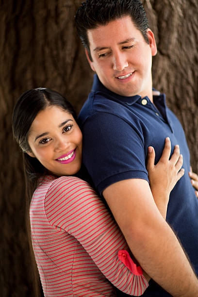 istock Young woman embracing husband from back and smiling 616884158