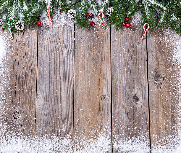 istock Rustic wooden boards with snow covered fir branches for Xmas 616884498
