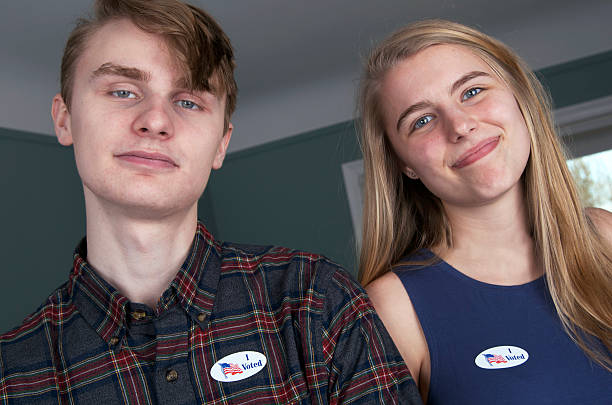 "i voted" stickers on two young voters - jovens a votar imagens e fotografias de stock