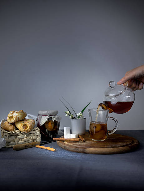 istock Still life. female hand pouring tea from a teapot into 616884688