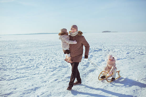 istock Father sledges his little daughters 616885664