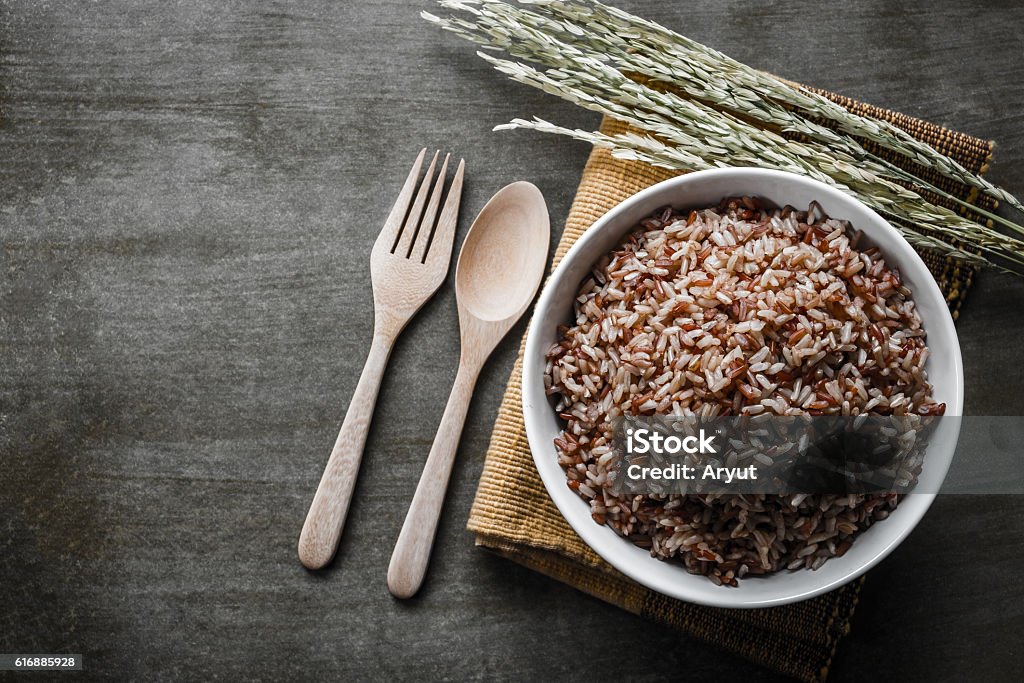 Brown Rice Brown Rice/Coarse rice with wooden spoon and fork, rice seed . Top view. Wholegrain Stock Photo