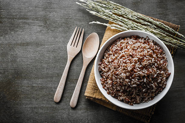 коричневый рис  - brown rice rice cooked healthy eating стоковые фото и изображения