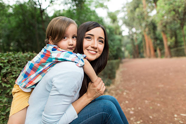 istock Happy young mother carrying her son on the back 616887542