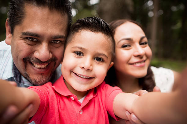 istock Latin family taking a selfie and smiling at camera 616887630