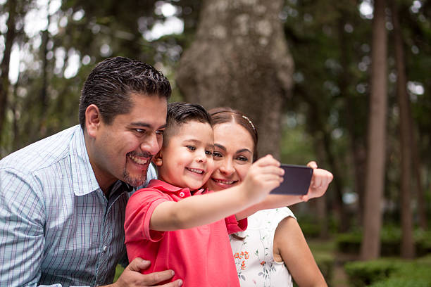 istock Little boy and parents taking selfie with mobile phone 616887740