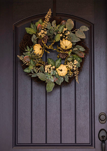 istock Ornate fall wreath with white pumpkins hanging on front door 616888844
