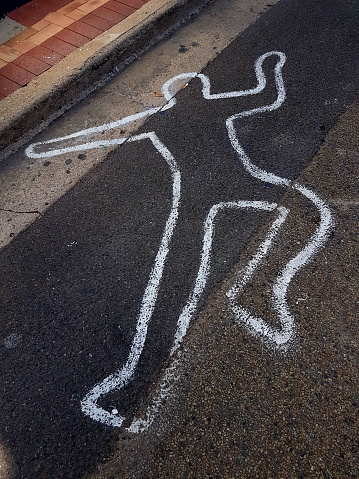 Painted outline of a person's body on bitumen / asphalt road