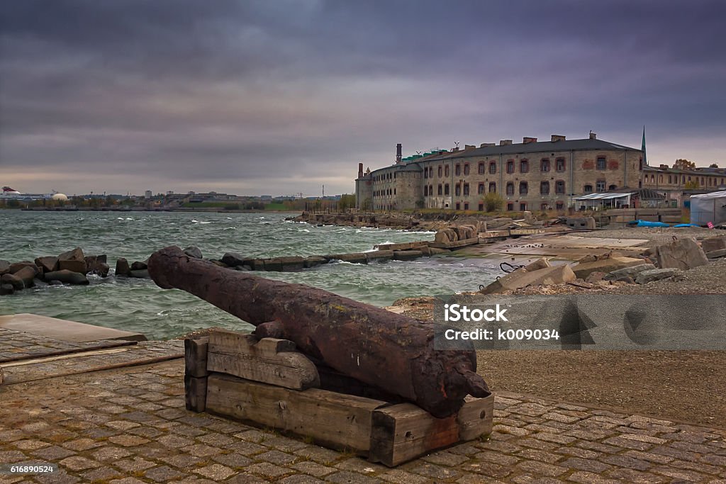Old Cannon And The Patarei Prison The old prison called Patarei in Tallinn, Estonia seen from the harbour. The old cannon is probably risen from the Baltic Sea. Abandoned Stock Photo