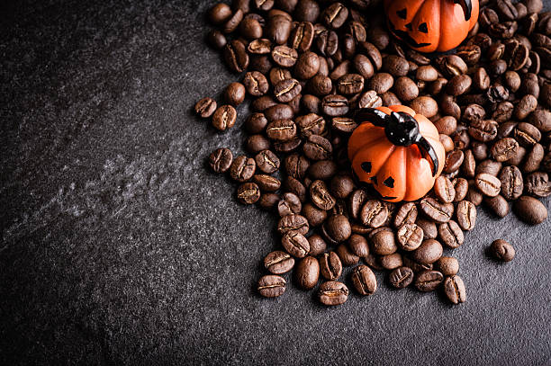 istock Halloween pumpkin decoration with coffee beans on dark background 616890762