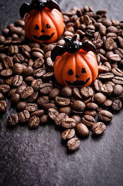 istock Halloween pumpkin decoration with coffee beans on dark background 616890780