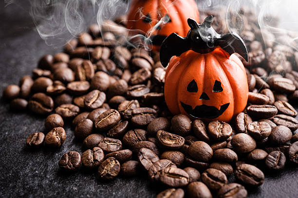 Halloween pumpkin decoration with coffee beans on dark background