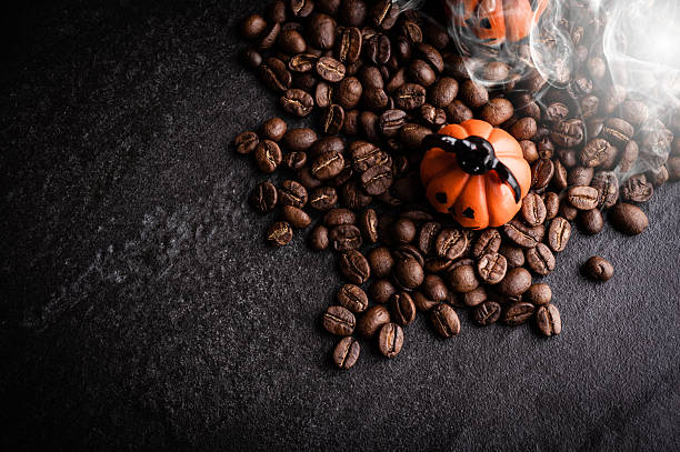 istock Halloween pumpkin decoration with coffee beans on dark background 616890824