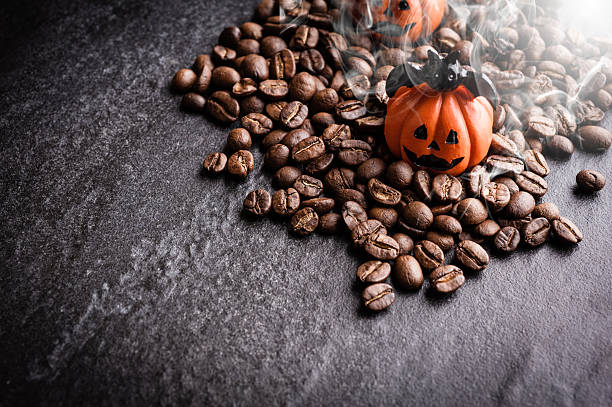 istock Halloween pumpkin decoration with coffee beans on dark background 616890848