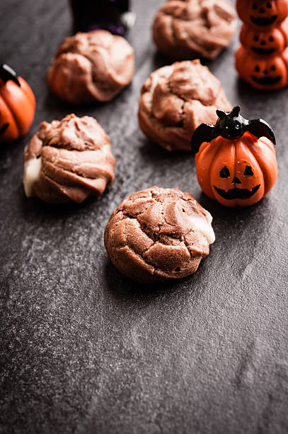 istock Eclairs with halloween decoration on black background 616890896