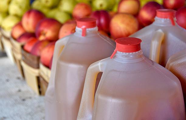 apple cider in gallon jugs autumn apple cider in plastic gallon jugs with apples at the market jug stock pictures, royalty-free photos & images