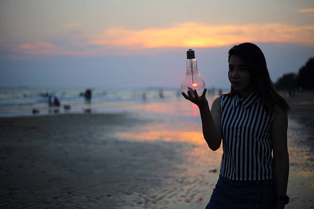 istock Woman holds the electric light bulb 616892458