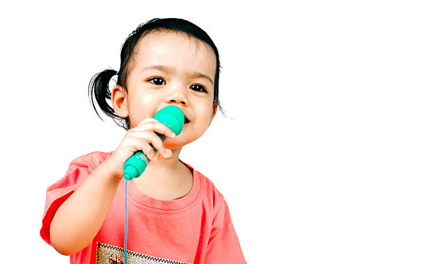 istock Young girl holding a microphone isolated on the white background 616892734