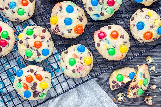 Shortbread cookies with multi-colored candy and chocolate chips on cooling rack, horizontal, top view
