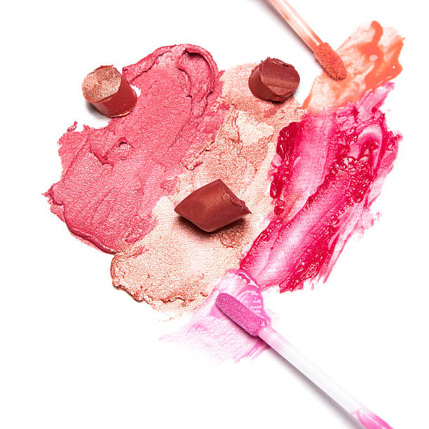 istock Smeared and sliced lipstick and lip gloss with brushes 616895276