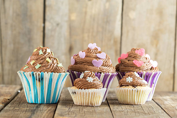 istock Vanilla cupcake with chocolate topping. Old wooden background. 616895386