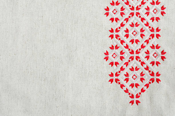 Embroidery design by red and white cotton threads on flax. Geometric ornament. Christmas background with embroidery.