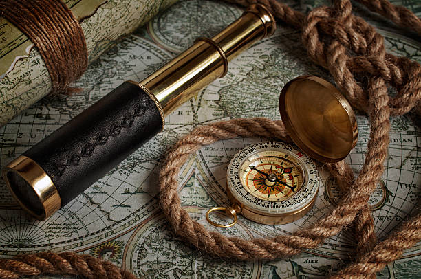 Nautical background with a navigation tools Nautical background with a navigation tools: telescope, compass and old maps old compass stock pictures, royalty-free photos & images