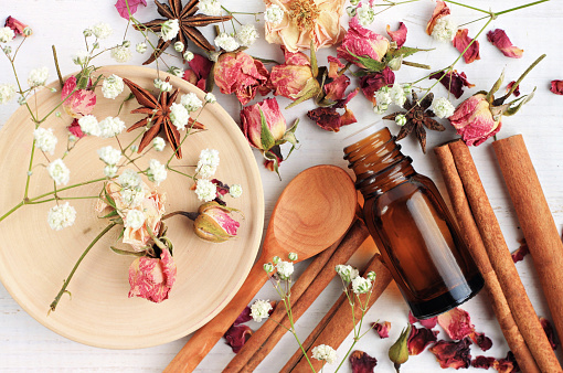  Herbal aroma beauty care. Dropper bottle, dried fragrant flowers, sticks, wooden utensils, top view background.