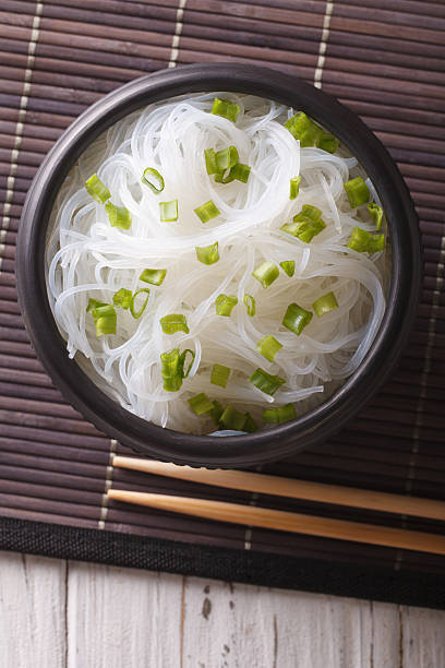 азиатская хрустальная лапша крупным планом в миске. вертикальный вид сверху - crystal noodles стоковые фото и изображения
