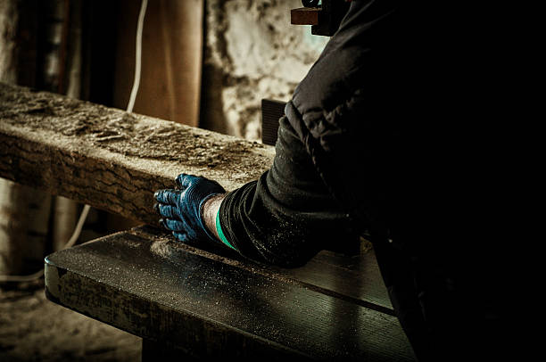 istock Carpenter cutting wood with saw 616904660