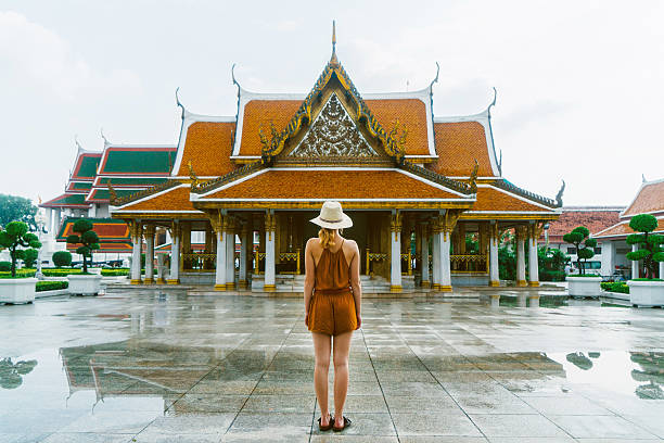 Young Caucasian woman walking  near the Wat Ratchanatdaram in Bangkok 