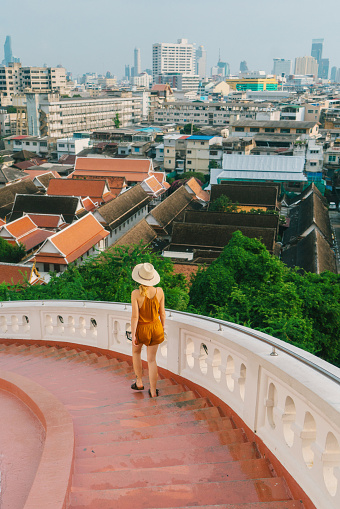 Woman walking on stairs on  the background of Bangkok 