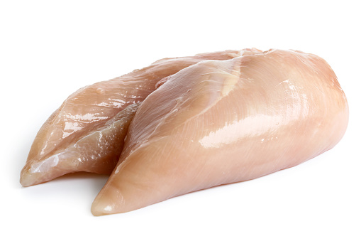 Whole skinned deboned raw chicken breasts isolated on white.