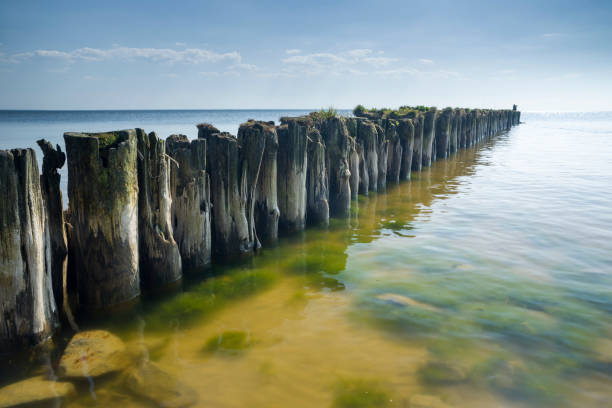 istock Groyne at calm sea under blue sky 617351934
