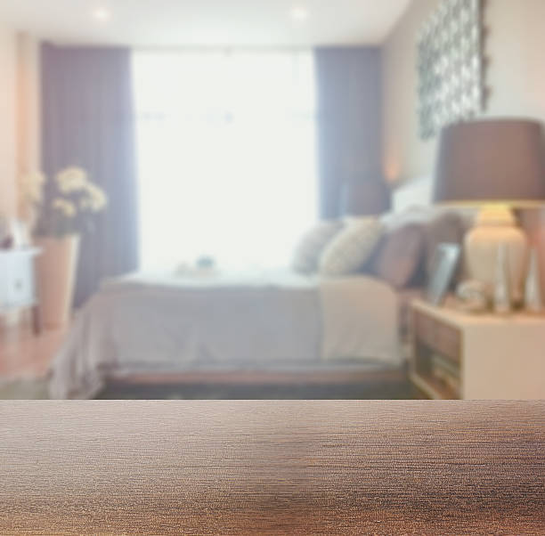 wooden table top with blur of bedroom in modern style stock photo