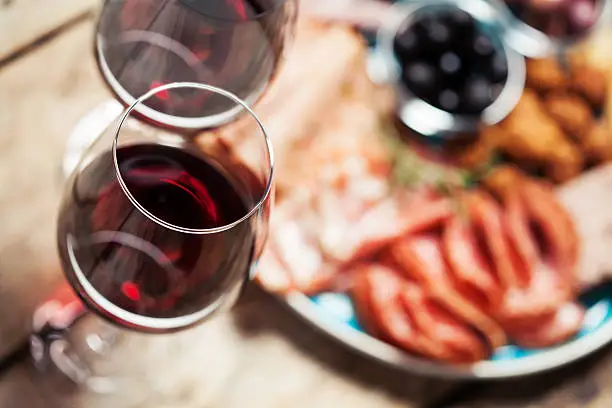 Red wine with charcuterie assortment on the background