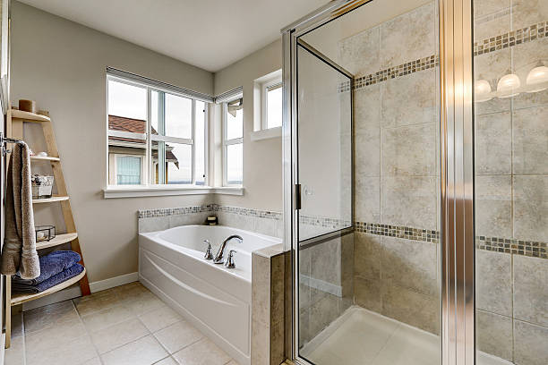 istock Glass shower and white bathtub in clean bathroom interior. 617356124