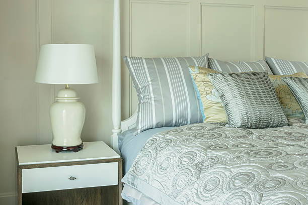 istock cozy bedroom with pillows and reading lamp on bedside table 617357186