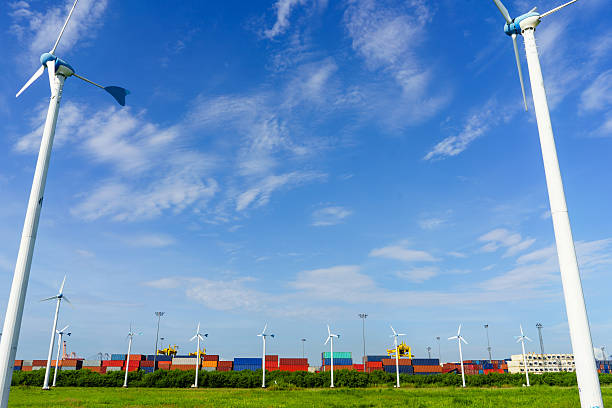 Cargo ship in port filled container, with wind turbines.