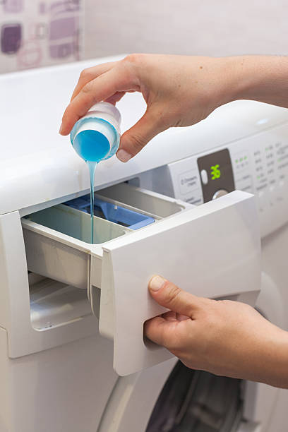 istock She pours the liquid powder in washing machine 617359282