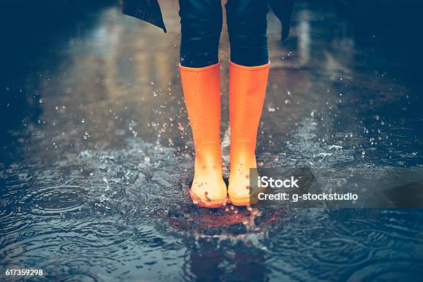 Feeling Protected In Her Boots Stock Photo - Download Image Now - Rubber Boot, Rain, Puddle