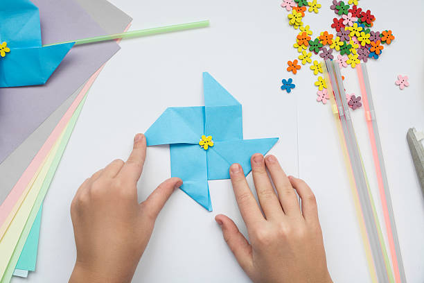 istock children's hands do origami 617359582