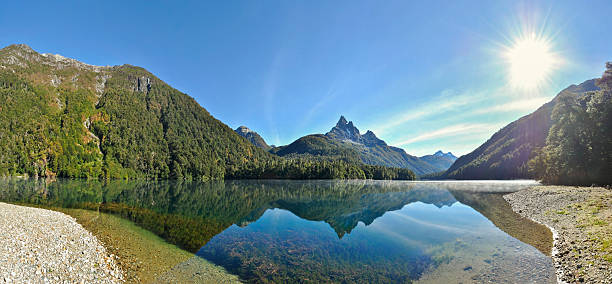 istock Golden light on beautiful reflection of a misty lake panorama 617359722